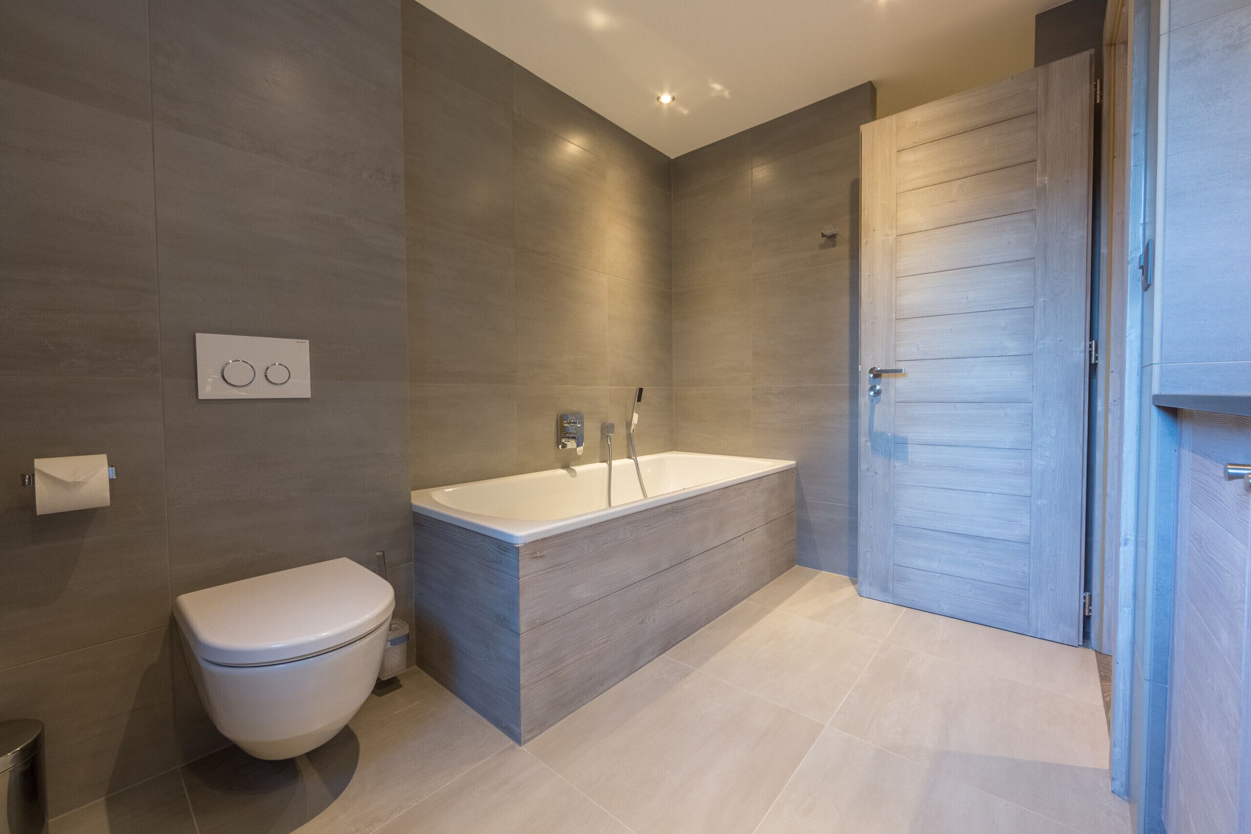 Une salle de bain moderne équipée de toilettes, d’une baignoire et d’une douche.