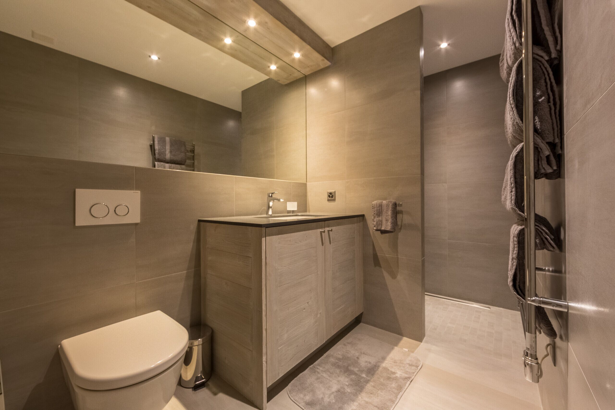 A modern bathroom with a toilet, sink, and shower area.