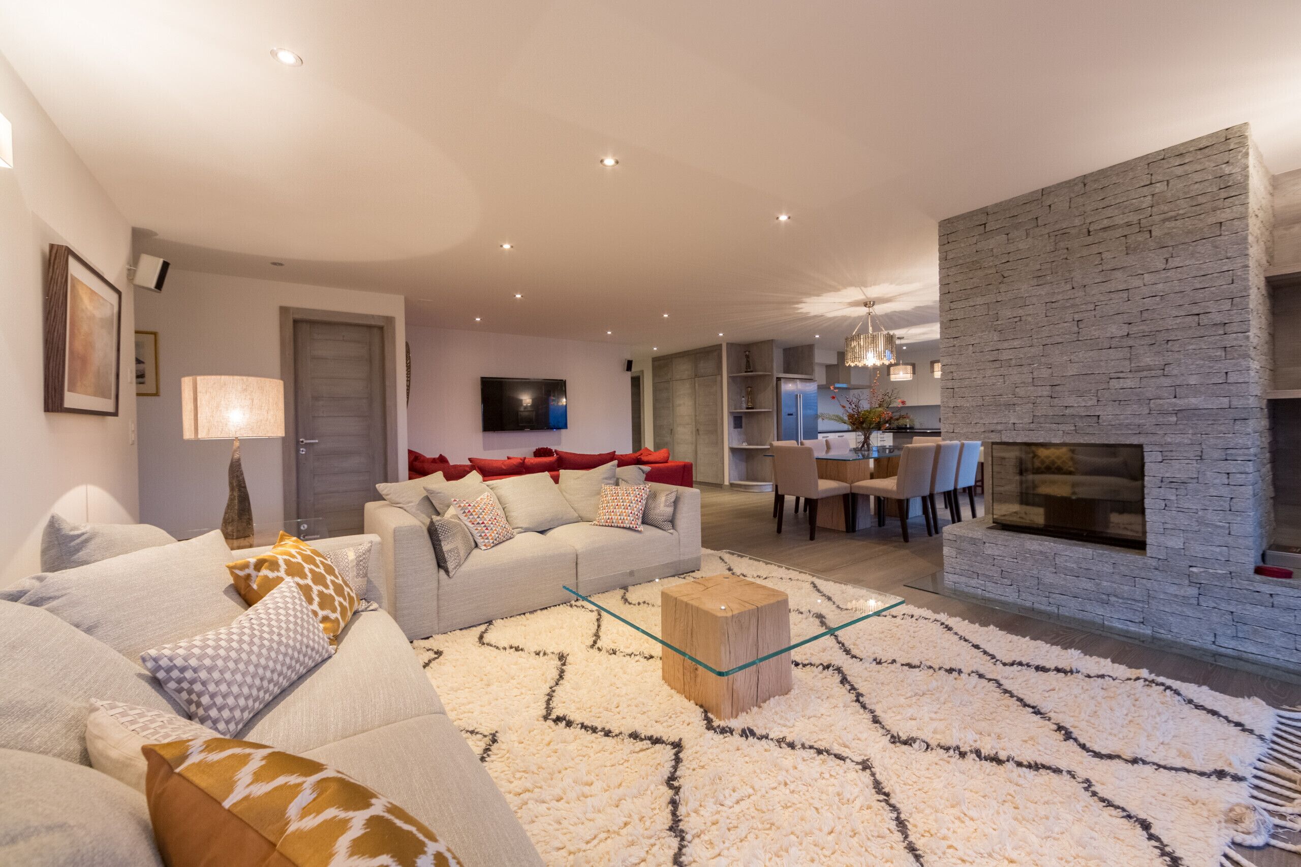 A modern living room with a sofa, coffee table, and a fireplace.