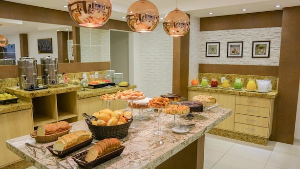 Un espace buffet proposant une variété d’aliments, notamment du pain, des pâtisseries et des fruits.