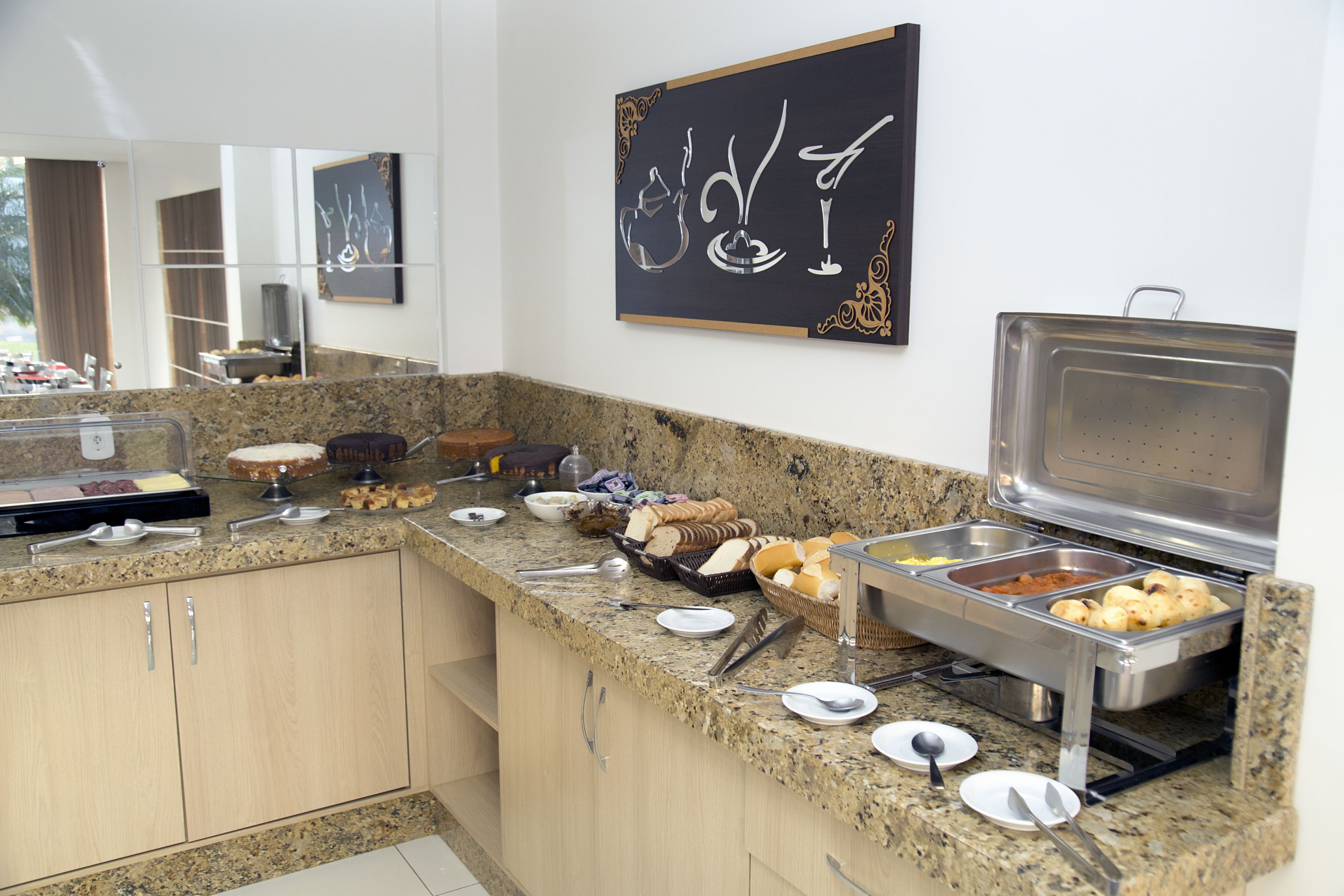 Un buffet proposant une variété de plats et d’ustensiles, le tout disposé sur un comptoir en granit.