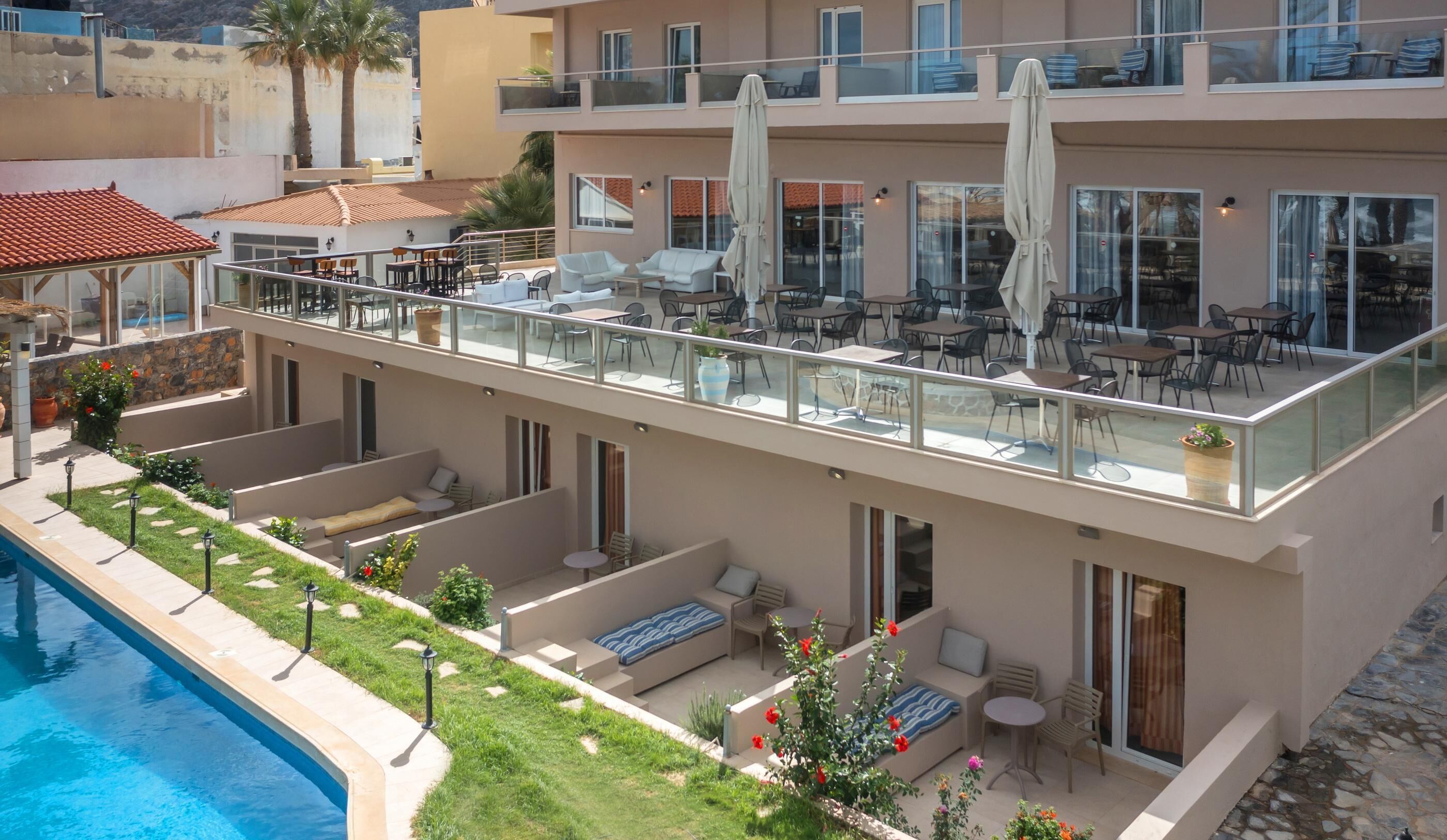 Un hotel de varios pisos con zonas de estar al aire libre, una piscina y un jardín.