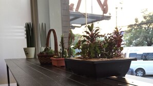 A wooden table with potted plants and a hanging planter. - Best Bed Suvarnabhumi - Hostel (Bang Phli)