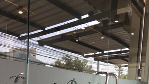 Une porte vitrée sur laquelle est affiché un panneau indiquant : « Service de livraison de plateaux-repas au lit de la meilleure qualité ».