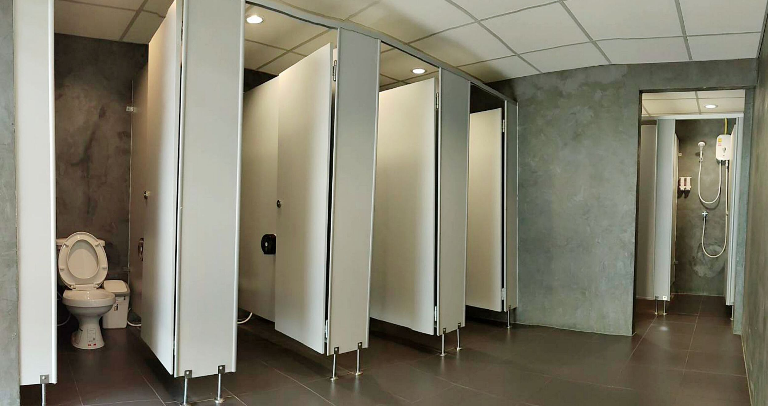 Uma casa de banho moderna com sanita, chuveiro e lavatório.
