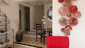 A dining area with a table, chairs, and a vase with branches.