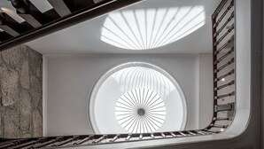 A modern staircase with a circular skylight and a wooden handrail. - Caléway Hotel (Vila Nova de Gaia)