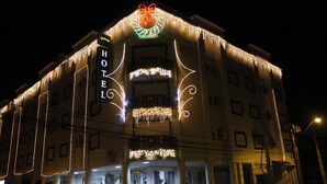 Un hotel con un letrero llamativo, varios balcones y luces decorativas.