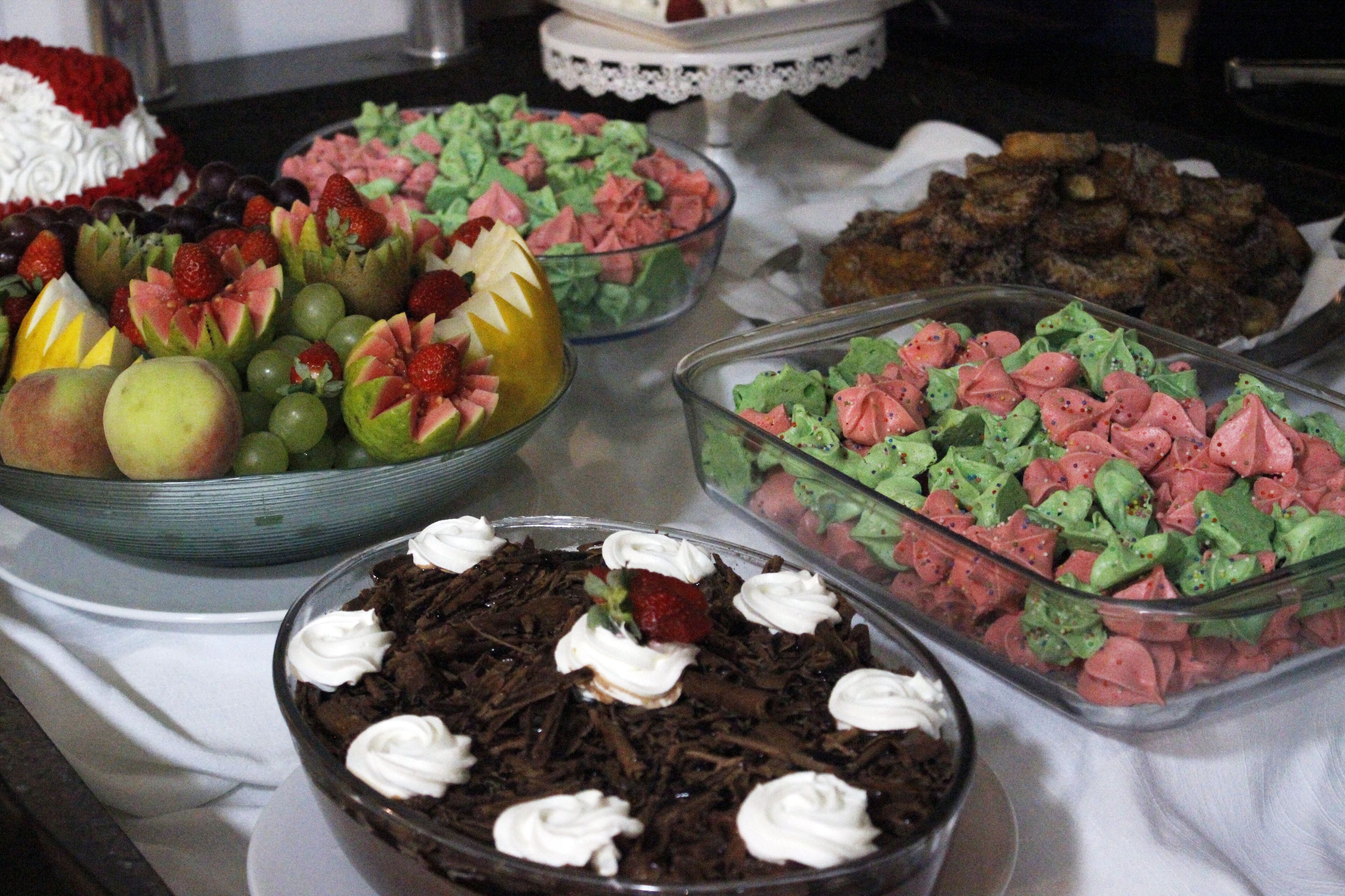 A buffet with various desserts including cakes, fruit, and other sweet treats.