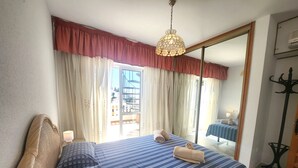 A hotel room with two beds, a large window, a mirror, and a hanging light fixture. - Sleeps 8 | Villa Pinomar | CG R865 (Nerja)