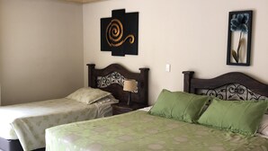 A bedroom with two single beds, a larger bed with green bedding, a wooden ceiling, and a wall-mounted artwork. - Hotel Bogota Inn Parkway (Bogotá)