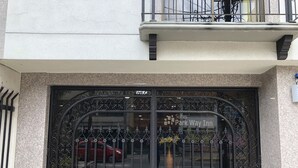 A gated entrance to a building with a sign for 'Suites Park Way Inn'. - Hotel Bogota Inn Parkway (Bogotá)