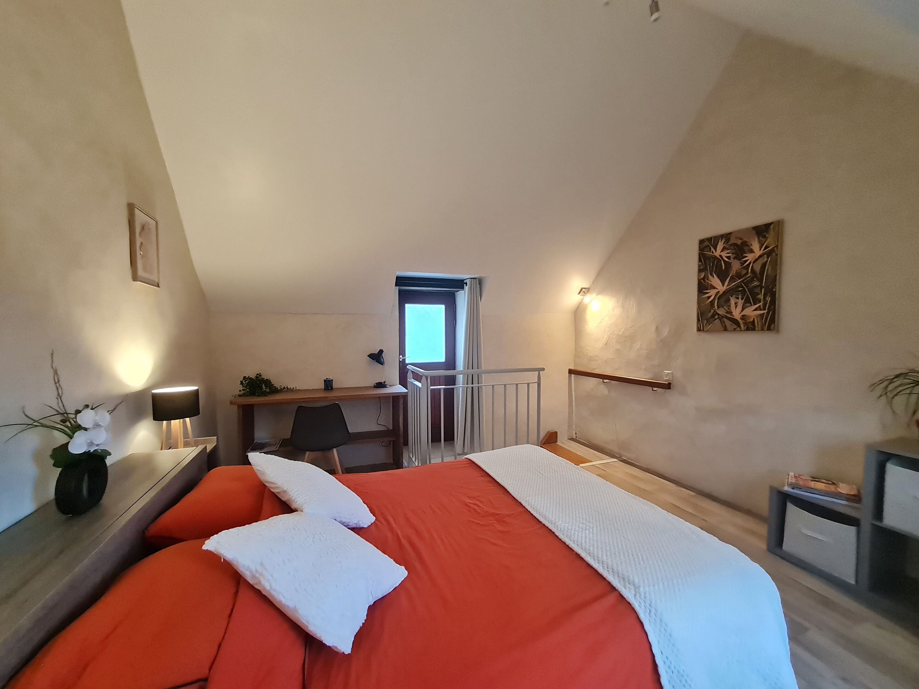 Un dormitorio con cama, escritorio, silla y ventana.
