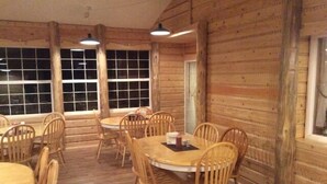 A rustic wooden interior with round tables and chairs, large windows, and a simple, functional design. - Alexander lake lodge (Cedaredge)
