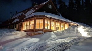 A log cabin with large windows, surrounded by snow. - Alexander lake lodge (Cedaredge)