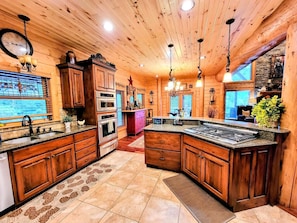 A kitchen with wooden cabinets, a central island, and built-in ovens.