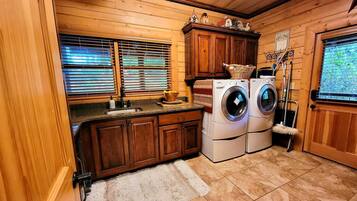 A compact laundry room with wooden cabinets, a washing machine, and a dryer.