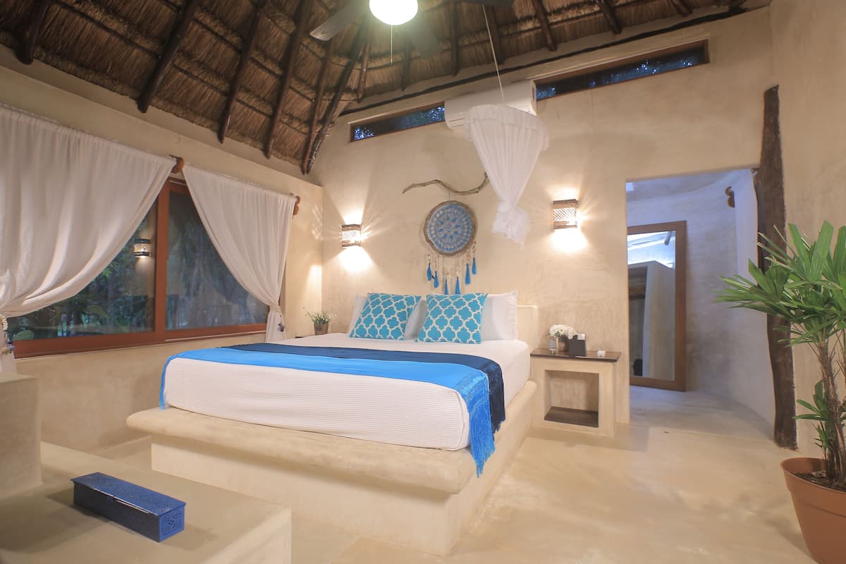 Ein Schlafzimmer mit Bett, Nachttisch und einer Zimmerpflanze.