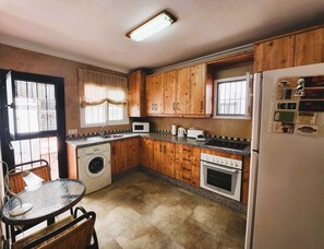 Compact kitchen with appliances, including a microwave, toaster, and oven, as well as a washing machine and refrigerator.
