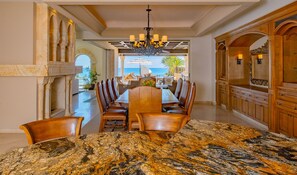 A dining area with a marble table, leather chairs, and a view of the ocean. - Gated Beach Front,Daily Housekeeping,Breakfast Service,Backyard OasisHot TubPool (Cabo San Lucas)