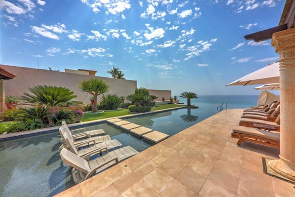 A pool area with lounge chairs and a clear view of the ocean. - Gated Beach Front,Daily Housekeeping,Breakfast Service,Backyard OasisHot TubPool (Cabo San Lucas)