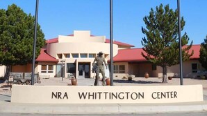 The exterior of the NRA Whittington Center with a statue in front, a red roof, and a clear sky. - Oasis Botique Motel (Raton)