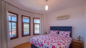 A bedroom with a bed, a nightstand, and three windows. - Spacious Villa with WiFi, A/C,  Private Pool and Rooftop Terrace
Licence 07-540  (Kalkan)