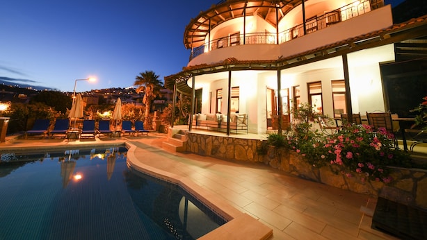 A two-story house with a swimming pool, outdoor seating, and a balcony. - Spacious Villa with WiFi, A/C,  Private Pool and Rooftop Terrace
Licence 07-540  (Kalkan)