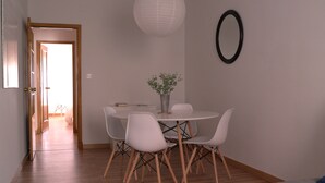 A dining area with a round table, white chairs, and a potted plant. - In the historic center of Ourense, it is ideal for families or groups  (Ourense)
