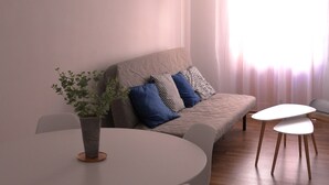 A modern living room with a sofa, a dining table with chairs, and two small side tables. - In the historic center of Ourense, it is ideal for families or groups  (Ourense)