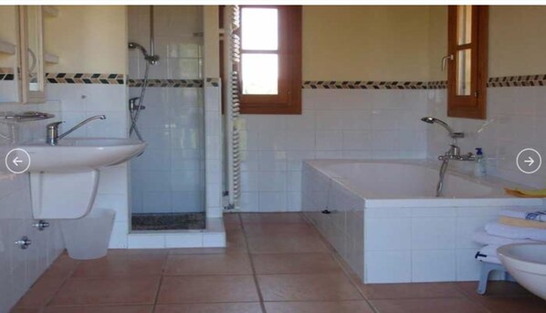 Ein Badezimmer mit Dusche, Waschbecken und Badewanne.