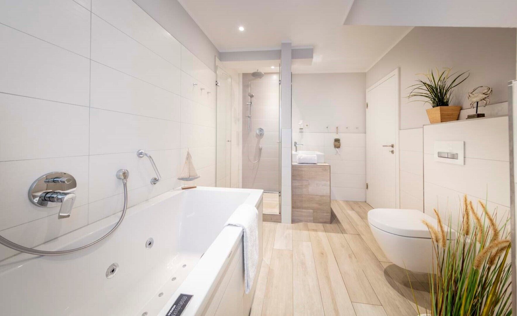 Een moderne badkamer met bad, toilet en douche.