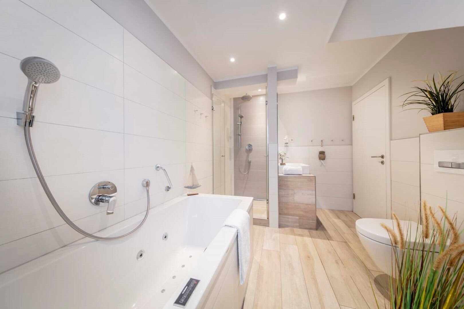 A modern bathroom with a bathtub, shower, and toilet.