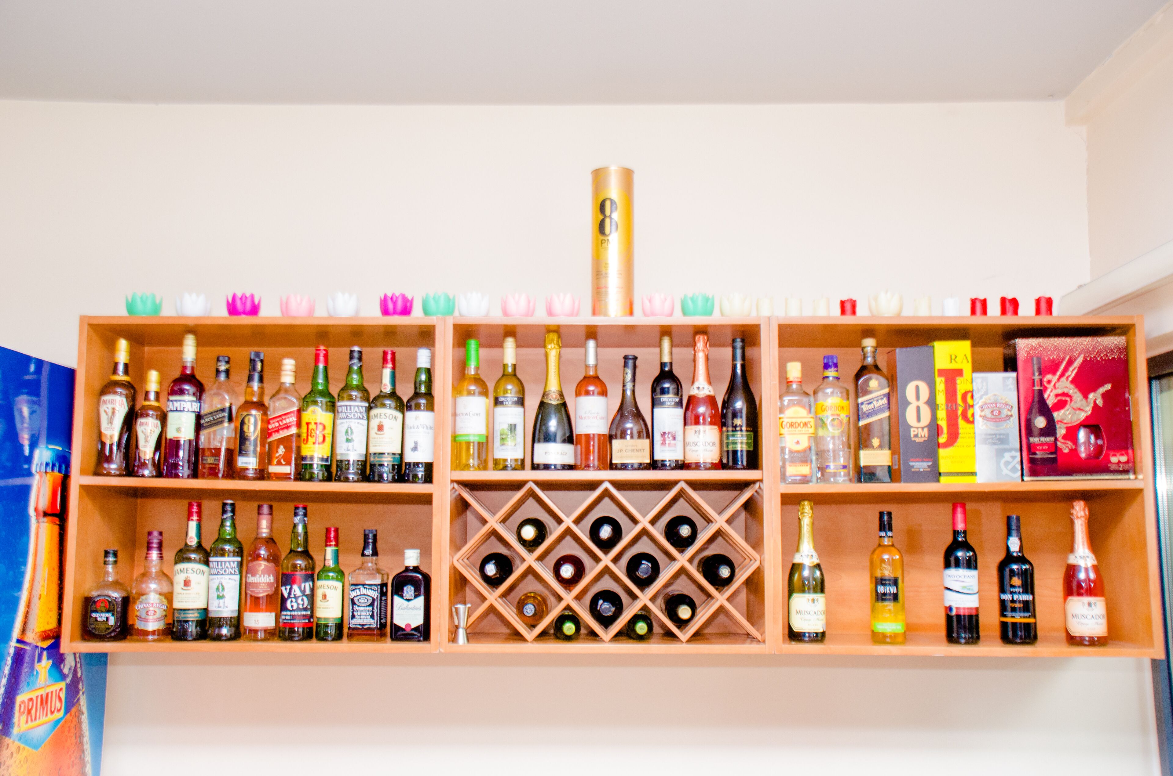 Un bar con varias estanterías llenas de botellas de licores y vasos.