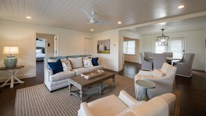 A spacious living room with a high ceiling, a ceiling fan, a dining area with chairs, and a kitchen in the background. - Dahlonega Resort and Vineyard (Dahlonega)