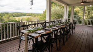 A covered outdoor dining area with tables set for a meal, overlooking a scenic landscape. - Dahlonega Resort and Vineyard (Dahlonega)