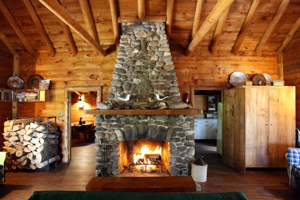 Living room with large wood burning fieldstone fireplace.