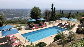 Een buitenzwembad en ligstoelen