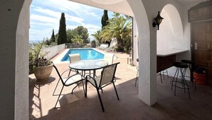 An outdoor patio with a pool, seating area, and a view of the surrounding landscape. - Holiday house - privatpool + glass fiber, views + aircondition, Wallbox (3,7kW) (El Mas Fumats)