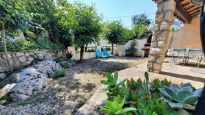 A garden area with a stone wall, a small pool, and outdoor seating.