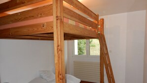 A bunk bed with a wooden frame and a window above it. - Apartment with harbor and sea view in Perros Guirec (Perros-Guirec)