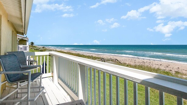 Un balcon avec vue sur la plage et l’océan.