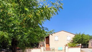A building with a stone wall, a metal gate, and a clear blue sky.