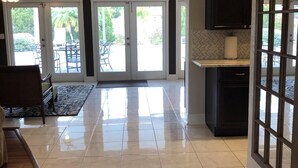 A spacious kitchen with a large island, dark cabinetry, and a view of the outdoors through sliding glass doors. - Tropical pool home close to the beach, never floods, high and dry  (Seminole)