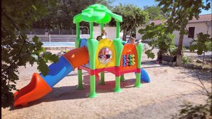 A playground with a slide and climbing structures.