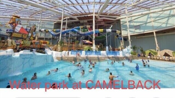 Un parc aquàtic interior amb diverses tobogans d'aigua i una gran piscina.