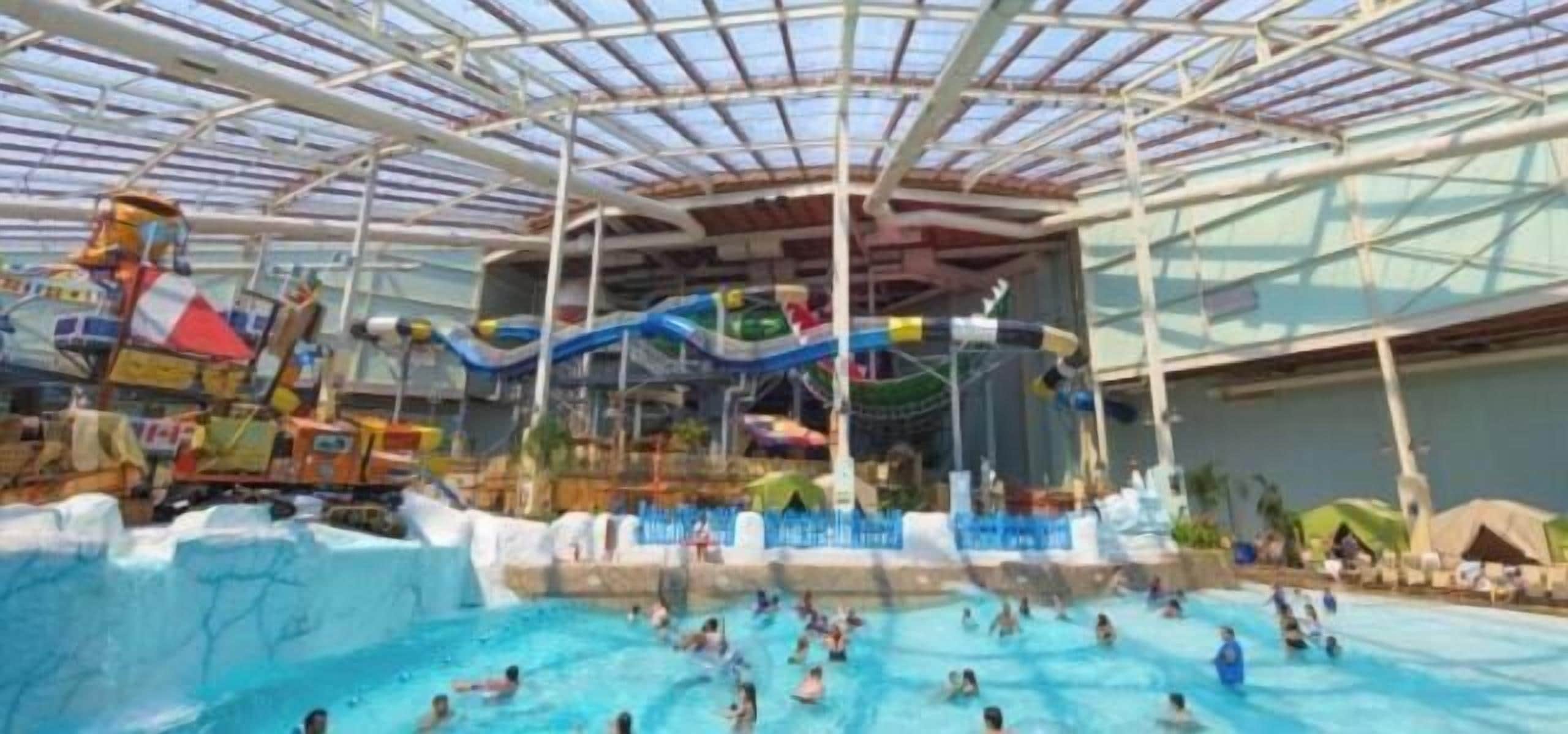 An indoor water park with multiple pools and water slides.