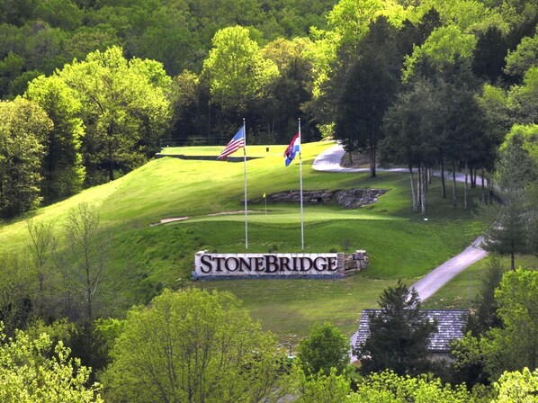 Un terrain de golf avec un panneau indiquant « StoneBridge » et deux drapeaux.