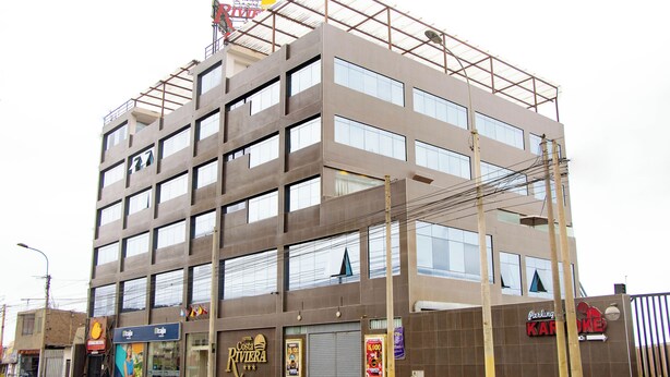 A multi-story hotel with a modern design, featuring large windows and a flat roof.