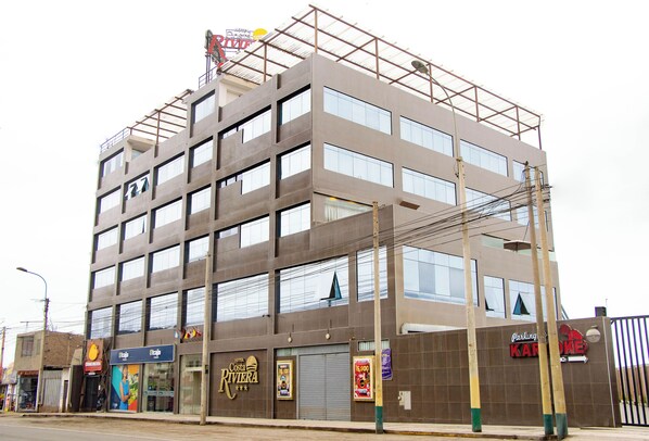 A multi-story hotel with a modern design, featuring large windows and a flat roof.